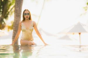 Portrait young beautiful asian woman happy smile and relax in swimming pool around hotel resort photo