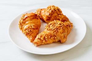 Fresh croissant with peanut on plate photo