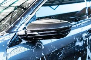 Close-up car side mirror with car washing foam photo