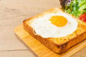 pan casero tostado con queso y huevo frito encima con ensalada de verduras para el desayuno foto