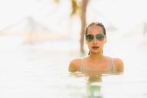 Portrait young beautiful asian woman happy smile and relax in swimming pool around hotel resort photo