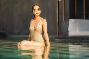Portrait young beautiful asian woman happy smile and relax in swimming pool around hotel resort photo