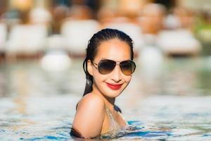 Portrait young beautiful asian woman happy smile and relax in swimming pool around hotel resort photo