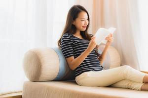 Portrait beautiful young asian woman reading book in on sofa in living room area photo