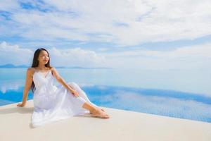 Portrait young asian woman relax smile happy around swimming pool in hotel and resort photo