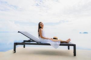 Portrait young asian woman relax smile happy around swimming pool in hotel and resort photo