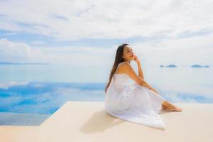 Portrait young asian woman relax smile happy around swimming pool in hotel and resort photo