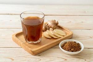 Hot and sweet ginger juice glass with ginger roots - Healthy drink style photo