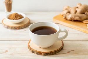 Hot and sweet ginger juice glass with ginger roots - Healthy drink style photo