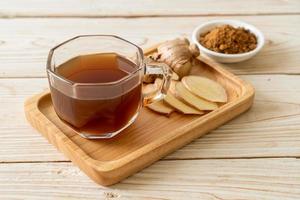 Hot and sweet ginger juice glass with ginger roots - Healthy drink style photo