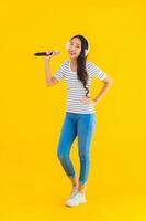 Portrait beautiful young asian woman singing with microphone
