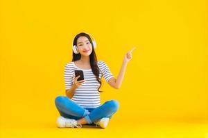 retrato, hermoso, joven, mujer asiática, uso, teléfono móvil inteligente, con, auriculares foto