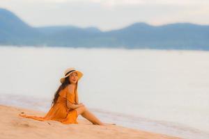 Portrait beautiful young asian woman happy smile relax on the beach sea ocean photo