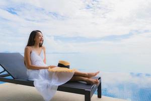 Portrait young asian woman relax smile happy around swimming pool in hotel and resort photo