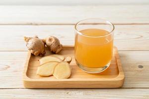 Fresh and hot ginger juice glass with ginger roots - Healthy drink style photo