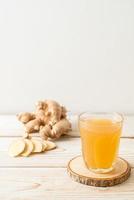 Fresh and hot ginger juice glass with ginger roots - Healthy drink style photo