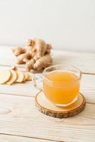 Fresh and hot ginger juice glass with ginger roots - Healthy drink style photo