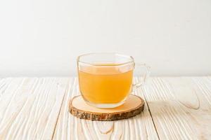 Fresh and hot ginger juice glass with ginger roots - Healthy drink style photo