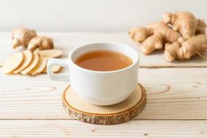 Fresh and hot ginger juice glass with ginger roots - Healthy drink style photo