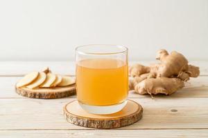 Fresh and hot ginger juice glass with ginger roots - Healthy drink style photo