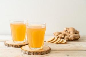 Fresh and hot ginger juice glass with ginger roots - Healthy drink style photo