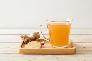 Fresh and hot ginger juice glass with ginger roots - Healthy drink style photo