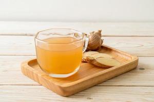 Fresh and hot ginger juice glass with ginger roots - Healthy drink style photo