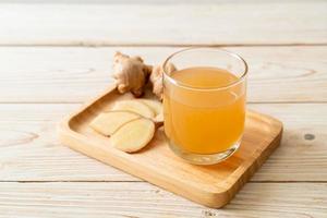 Fresh and hot ginger juice glass with ginger roots - Healthy drink style photo