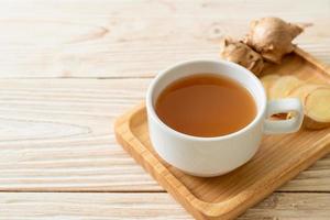 Fresh and hot ginger juice glass with ginger roots - Healthy drink style photo