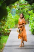 Portrait beautiful young asian woman walk on path walk in the garden photo