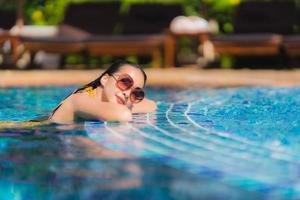Portrait beautiful young asian woman leisure relax smile and happy around swimming pool in hotel resort photo