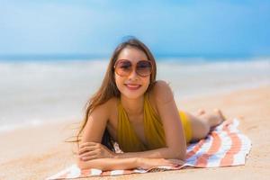 Portrait beautiful young asian woman smile happy on the beach and sea photo