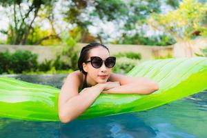 Portrait beautiful young asian woman smile happy relax and leisure in the swimming pool photo