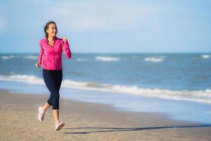 retrato, hermoso, joven, mujer asiática, funcionamiento, y, ejercicio, en, el, tropical, al aire libre, naturaleza, playa, mar, océano foto