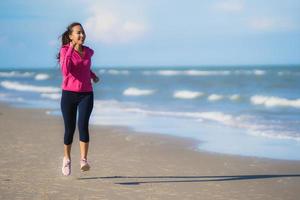 retrato, hermoso, joven, mujer asiática, funcionamiento, y, ejercicio, en, el, tropical, al aire libre, naturaleza, playa, mar, océano foto