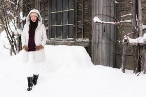 Hermosa joven asiática sonriendo feliz para viajar en la temporada de invierno con nieve foto