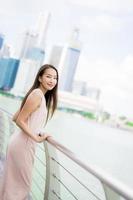 Hermosa mujer asiática sonríe y feliz de viajar a la ciudad de Singapur foto