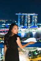Hermosas mujeres asiáticas sonríen y felices con la vista de la ciudad de Singapur foto