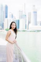 Hermosa mujer asiática sonríe y feliz de viajar a la ciudad de Singapur foto