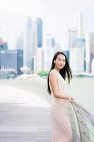 Hermosa mujer asiática sonríe y feliz de viajar a la ciudad de Singapur foto