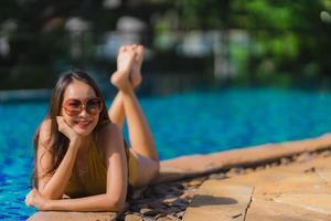 Portrait beautiful young asian woman leisure relax smile and happy around swimming pool in hotel resort photo
