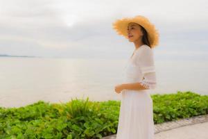 Portrait beautiful asian woman wear hat with smile happy leisure on the beach and sea in holiday vacation photo