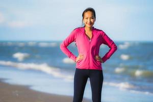 retrato, hermoso, joven, mujer asiática, funcionamiento, y, ejercicio, en, el, tropical, al aire libre, naturaleza, playa, mar, océano foto