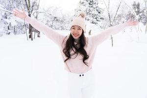 Retrato joven hermosa mujer asiática sonríe feliz viaje y disfruta con la nieve en la temporada de invierno foto