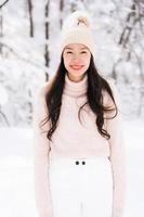 Retrato joven hermosa mujer asiática sonríe feliz viaje y disfruta con la nieve en la temporada de invierno foto