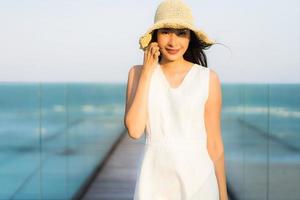 retrato, hermoso, joven, mujer asiática, feliz, y, sonrisa, en, el, playa, mar y océano foto