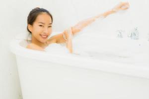 retrato, hermoso, joven, mujer asiática, tomar una bañera, en, cuarto de baño foto