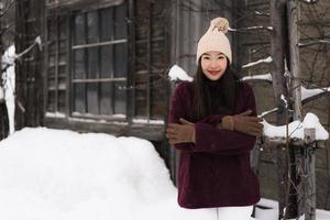 Beautiful young asian woman smiling happy for travel in snow winter season photo