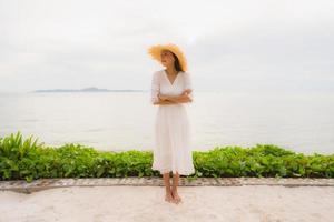 Portrait beautiful asian woman wear hat with smile happy leisure on the beach and sea in holiday vacation photo