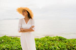 Portrait beautiful asian woman wear hat with smile happy leisure on the beach and sea in holiday vacation photo